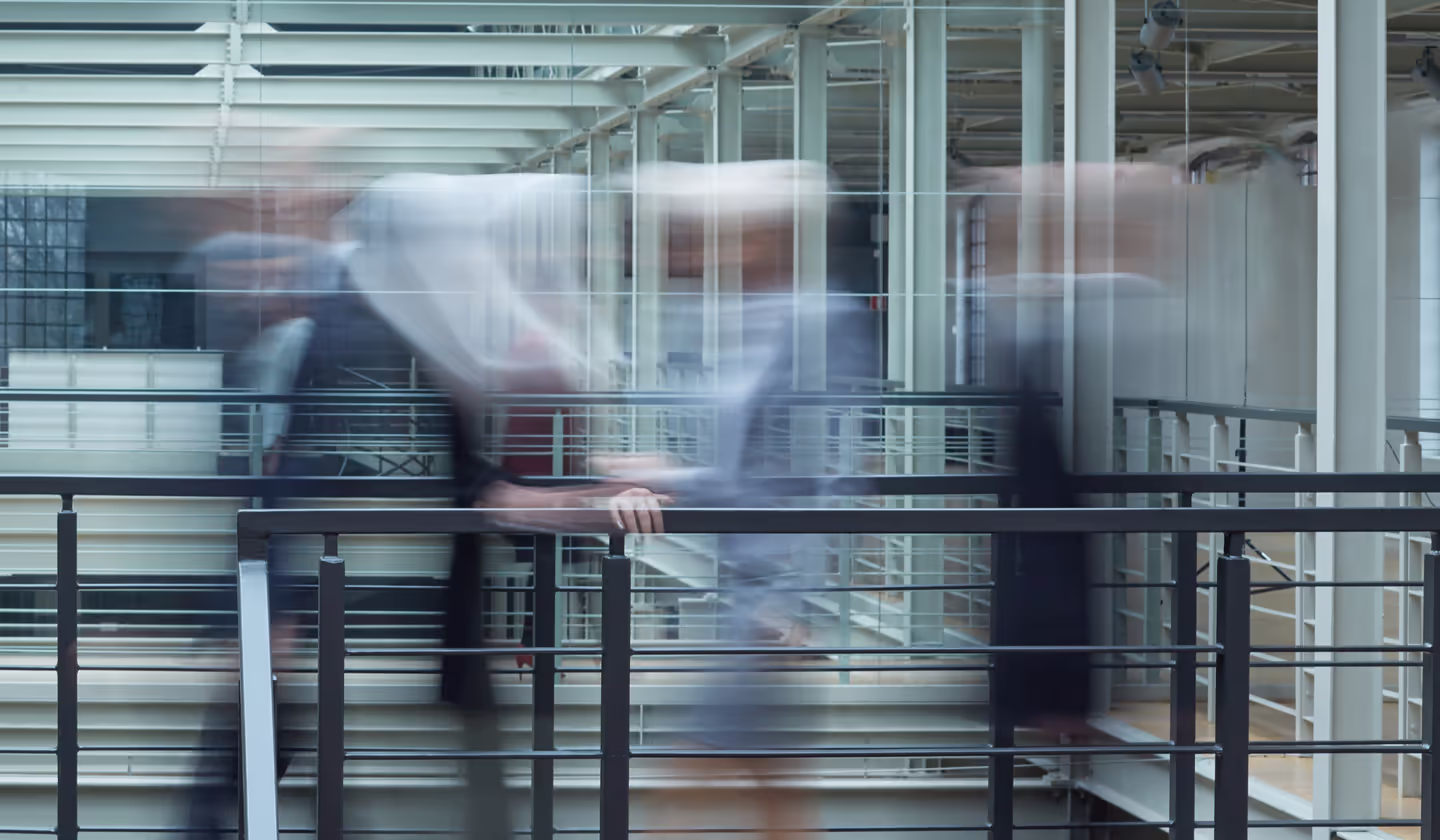A person walking through a modern glass-walled office