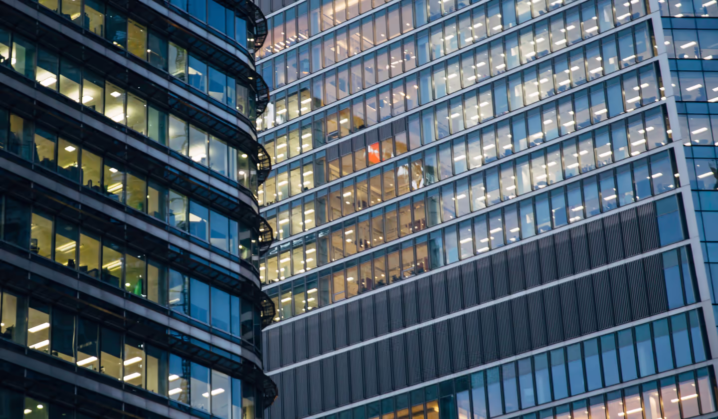 Lit office towers in a financial district at dusk